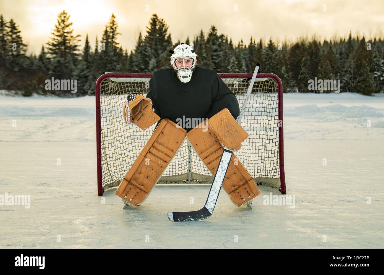 Gardien de but de hockey dehors en hiver avec de beaux équipements Banque D'Images