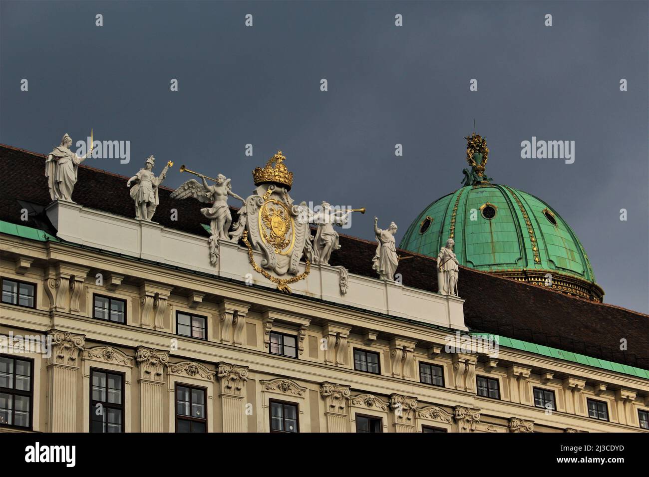 Vue sur les sculptures sur le toit du palais impérial de Hofburg avec le dôme de Hofburg en arrière-plan vu depuis la place du château intérieur. Banque D'Images