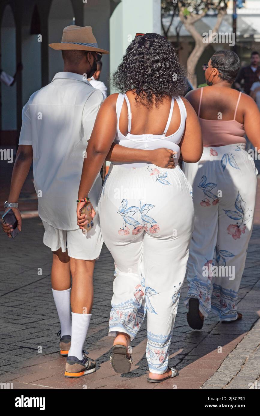 Le Cap, Afrique du Sud. 2022. Vue arrière de deux dames et un homme mince marchant sur le front de mer à Cape Town. Banque D'Images