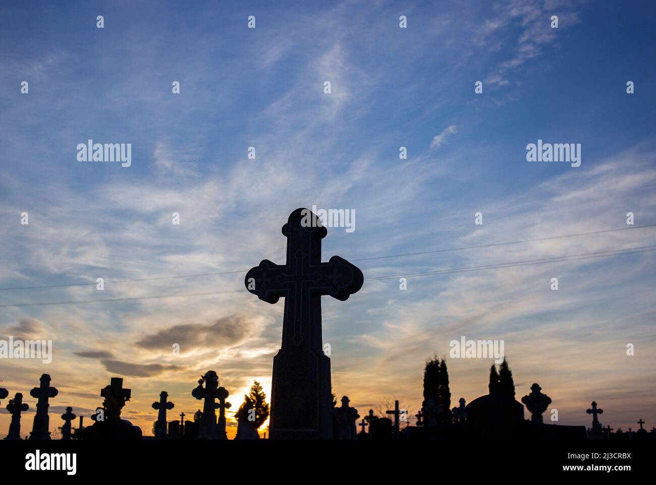 silhouettes de croix en contre-jour au cimetière sur fond de ciel de coucher de soleil . Traditions sépultures chrétiennes. Chagrin, tristesse, deuil, fin de vie, v Banque D'Images