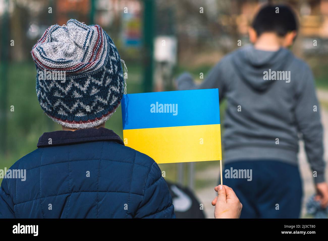 Enfants ou enfants avec vêtements d'hiver, chapeau et drapeau ukrainien, le profil de l'enfant est sur le drapeau. La guerre en Ukraine, causée par Poutine et la Russie, réfugié Banque D'Images