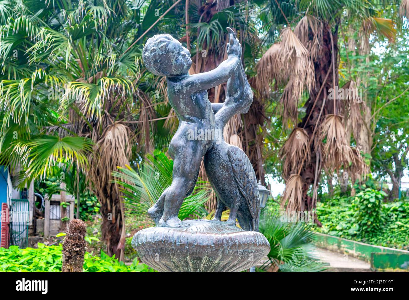 Une sculpture métallique d'un enfant poussant la tête d'un oiseau est vue dans le zoo de la Havane. Le célèbre lieu est connu populairement sous le nom de Zoologico de 26. Le Banque D'Images