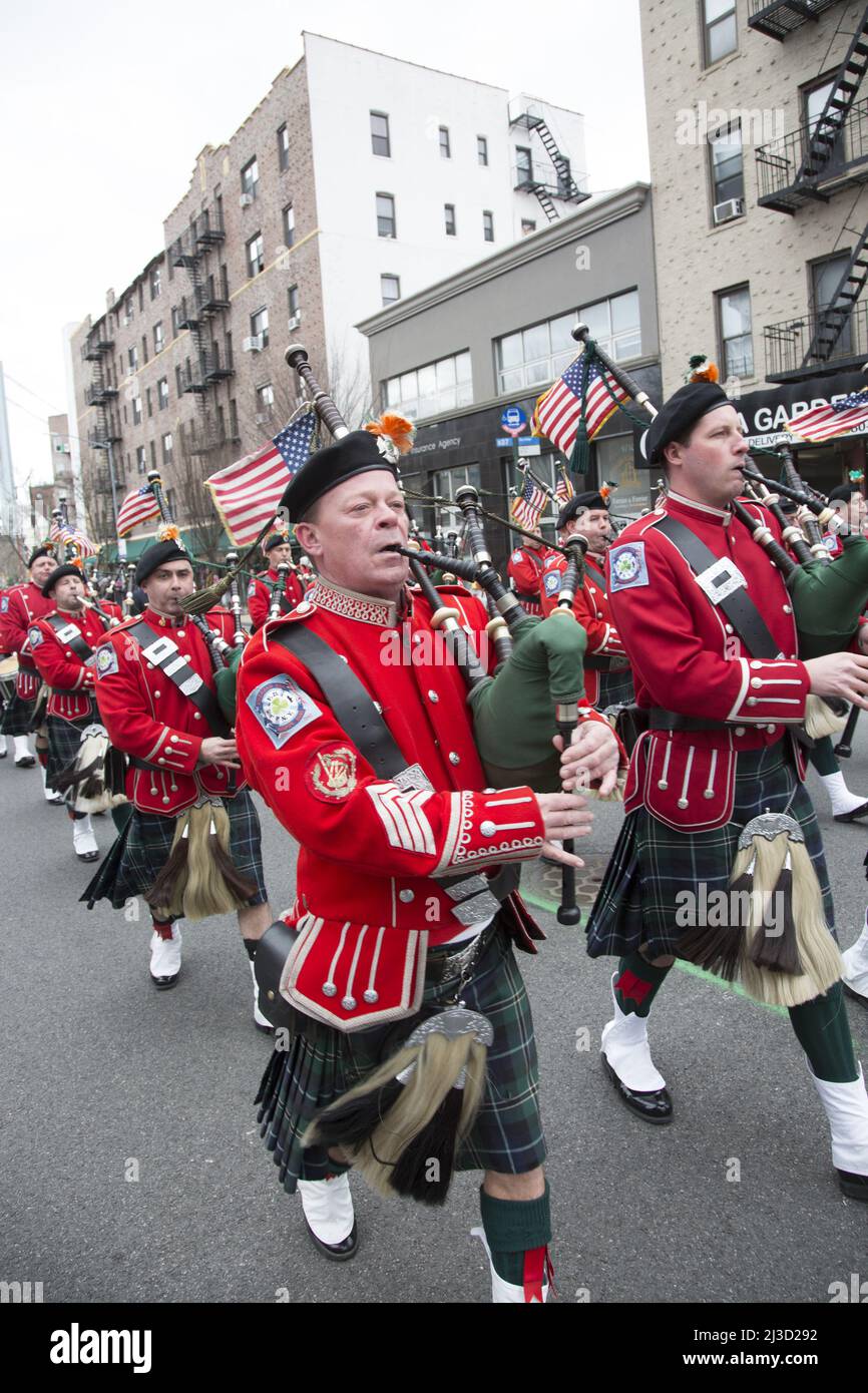 New York Fire Department Emerald Society Pipe Band marche dans Bay Ridge, Brooklyn Saint Patrick's Day Parade à Brooklyn, NY. La tour du pont Verrazano se distingue en arrière-plan. Banque D'Images