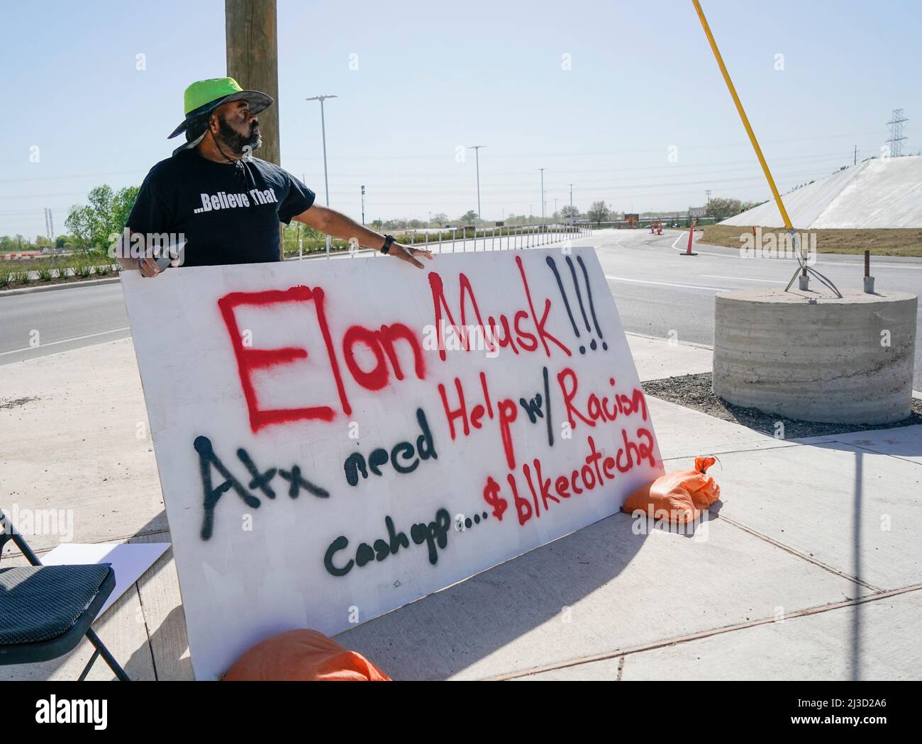 Austin, Texas, États-Unis. 7th avril 2022. Le stratège communautaire VICTOR REED, d'Austin, se trouve à l'extérieur de l'usine de Tesla de 1,1 milliards de dollars, près de l'aéroport d'Austin, avec un panneau demandant au PDG Elon Musk (non illustré) d'investir dans des travailleurs de la technologie noire le 7 avril 2022. L'usine a sa grande célébration privée d'ouverture plus tard aujourd'hui. (Image de crédit : © Bob Daemmrich/ZUMA Press Wire) Banque D'Images