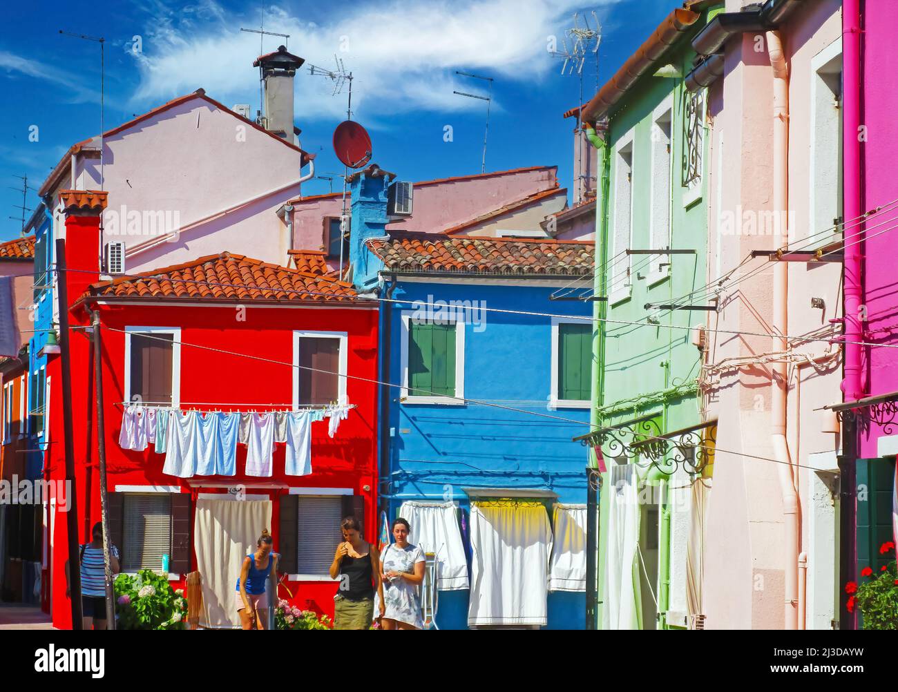 Venise (Burano), Italie - mai 9. 2019: Vue sur la place avec des maisons lumineuses colorées, la buanderie est suspendue à l'extérieur pour sécher, ciel bleu Banque D'Images