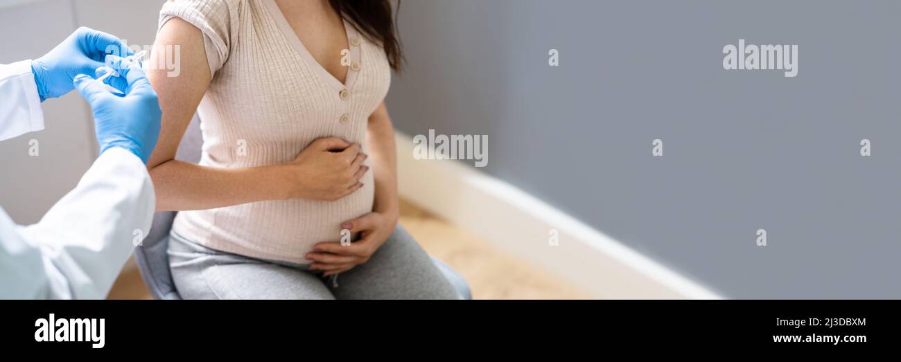 Médecin effectuant l'injection du vaccin Covid-19 à la femme enceinte patient Banque D'Images