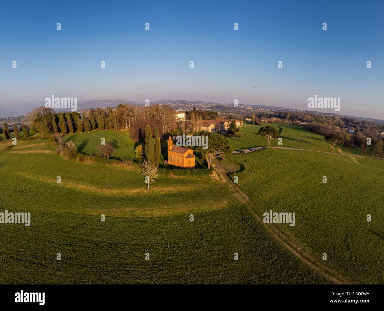 Tir de drone aérien. Église rouge de Pomelasca au coucher du soleil - vue sur la campagne Lombardie, Inverigo, province de Côme, Italie Banque D'Images