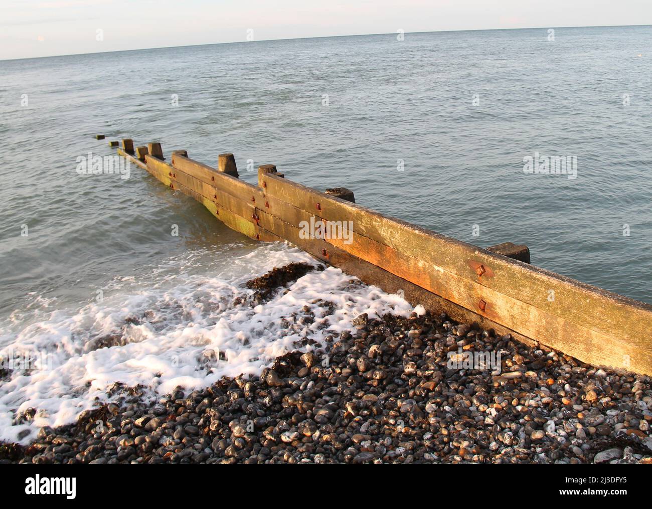 Une Groyne côtière en bois sur une plage de Stony. Banque D'Images