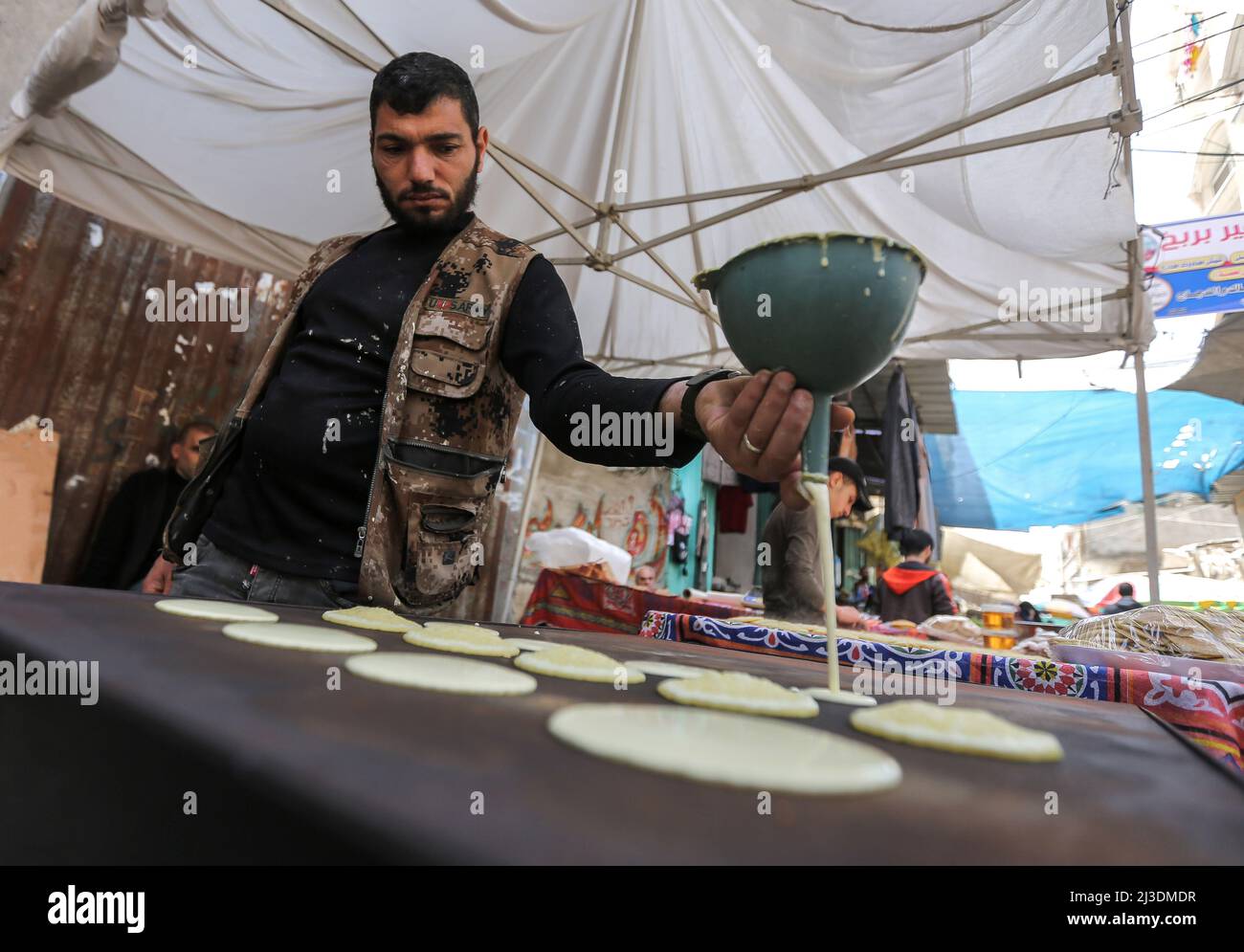 Les Palestiniens magasinent sur un marché pendant le mois Saint du Ramadan dans le camp de Khan Yunis, dans le sud de la bande de Gaza, en raison d'une hausse des prix due à l'invasion russe de l'Ukraine. Palestine. Banque D'Images