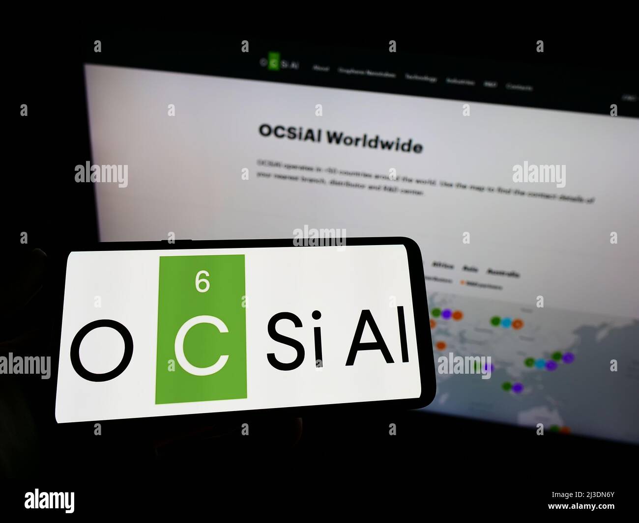 Personne tenant un smartphone avec le logo de la société luxembourgeoise OCSiAl à l'écran devant le site. Mise au point sur l'affichage du téléphone. Banque D'Images