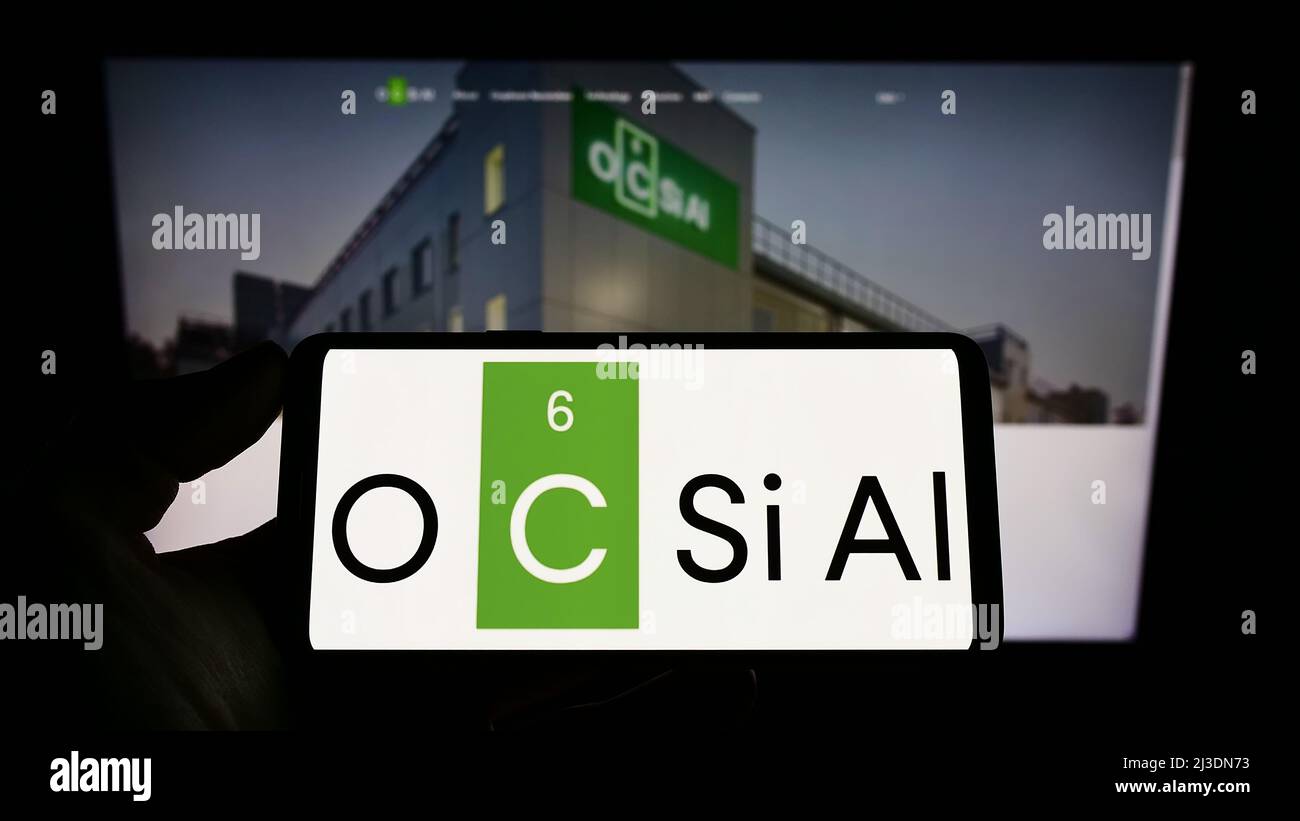 Personne tenant un téléphone portable avec le logo de la société luxembourgeoise OCSiAl sur l'écran devant la page web d'affaires. Mise au point sur l'affichage du téléphone. Banque D'Images