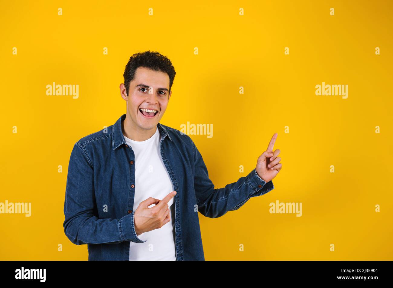 Portrait du jeune homme positif hispanique souriant sur fond jaune au Mexique en Amérique latine Banque D'Images Portrait du jeune homme positif hispanique souriant sur fond jaune au Mexique en Amérique latine Banque D'Images