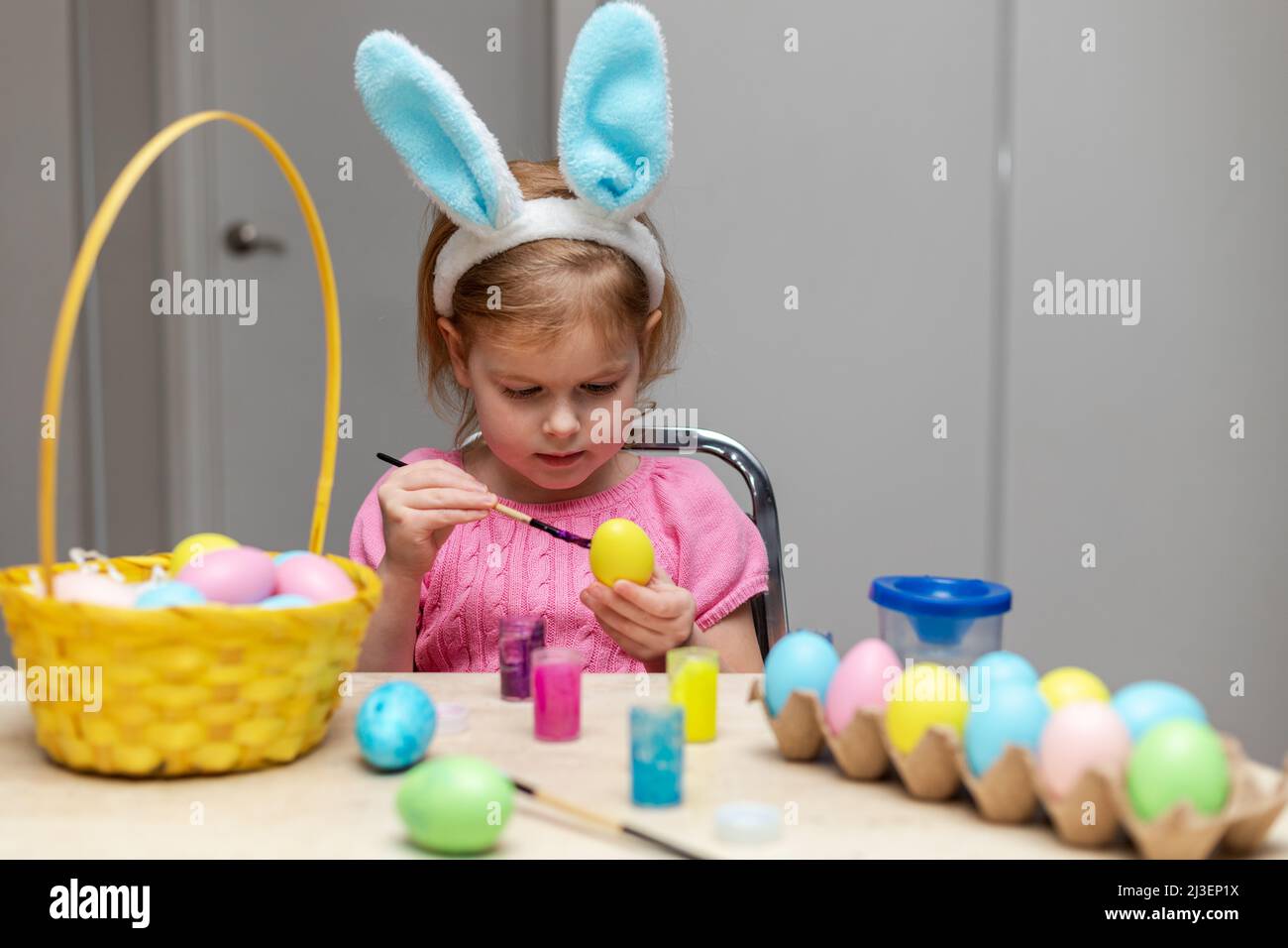 Un petit enfant peint des œufs de Pâques. Petit enfant faisant des décorations de vacances. Fille faisant de l'artisanat Banque D'Images