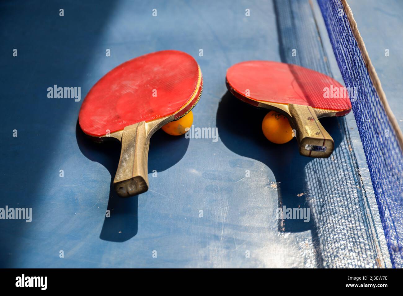 SURABAYA, INDONÉSIE - 06 MARS 2020 : deux raquettes et balles de tennis de table ou de ping-pong sur une table et un filet bleus Banque D'Images