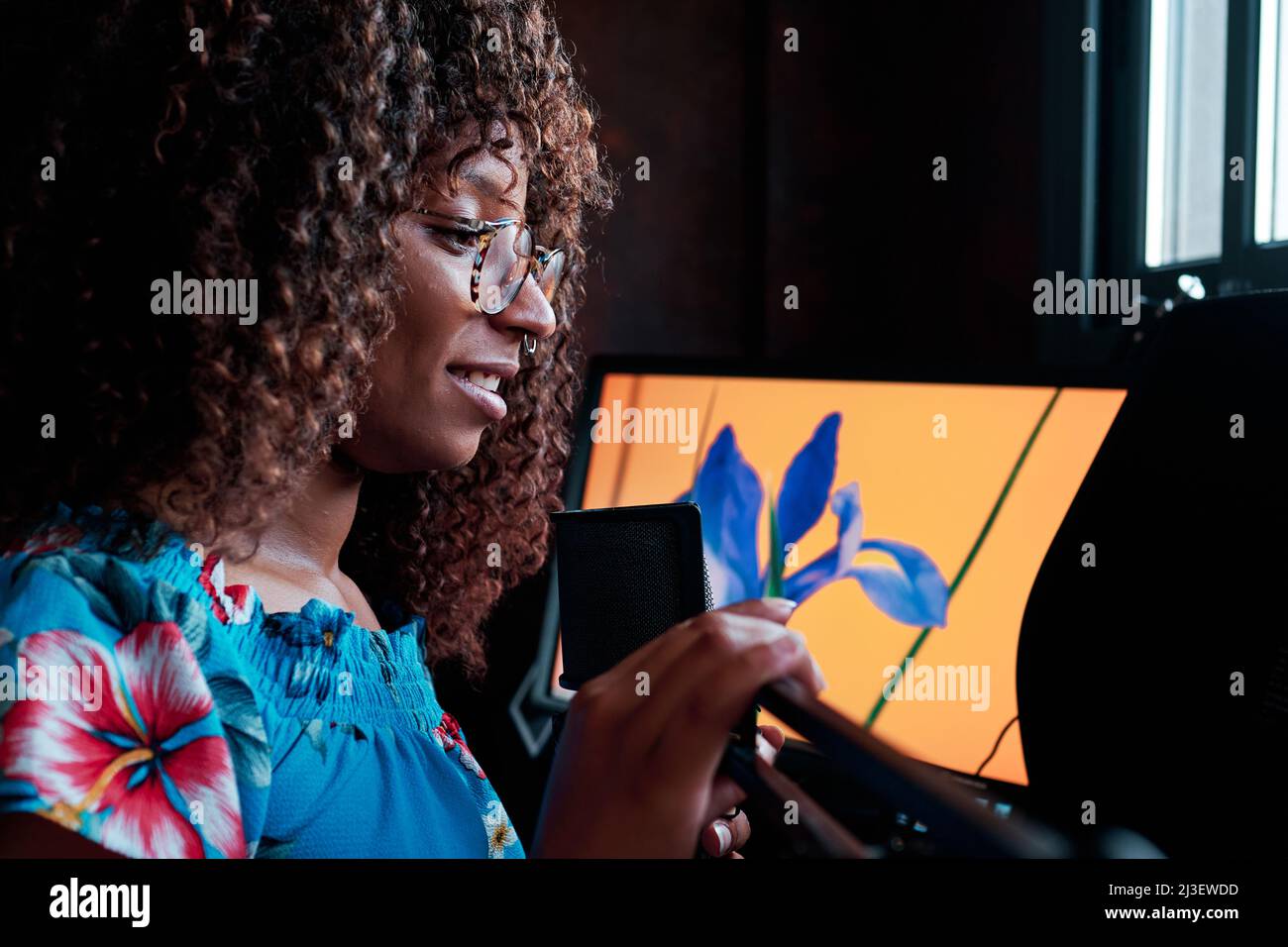 jeune artiste afro-américain baladodiffusion avec un microphone devant son ordinateur Banque D'Images