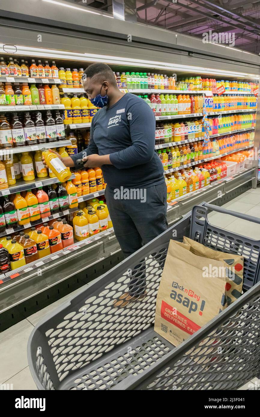 Cape Town, Afrique du Sud - 9 septembre 2021 : un membre du personnel cueille des produits à partir de l'étagère pour un service de livraison express à domicile Banque D'Images