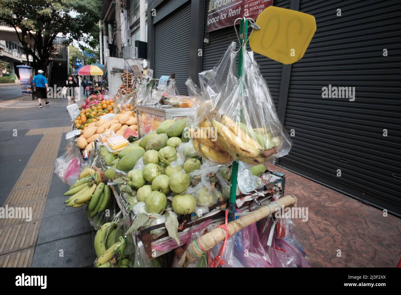 Fruits frais vendeurs de nourriture de rue sur Sukhumvit Road zone touristique entre Soi Asoke et Soi Nana à Bangkok en Thaïlande Banque D'Images