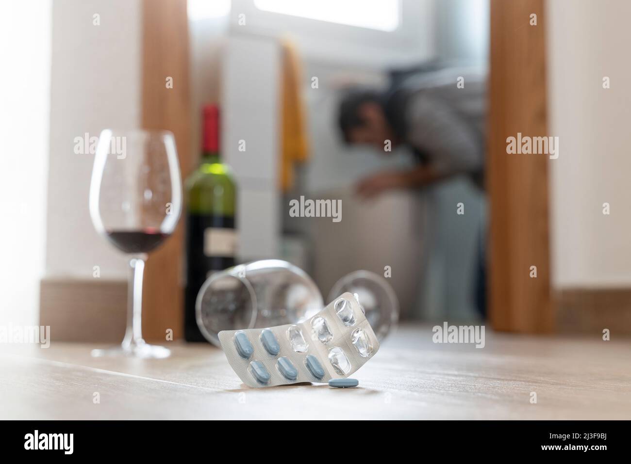 Homme dans les toilettes qui se jette après avoir consommé de l'alcool et des drogues Banque D'Images