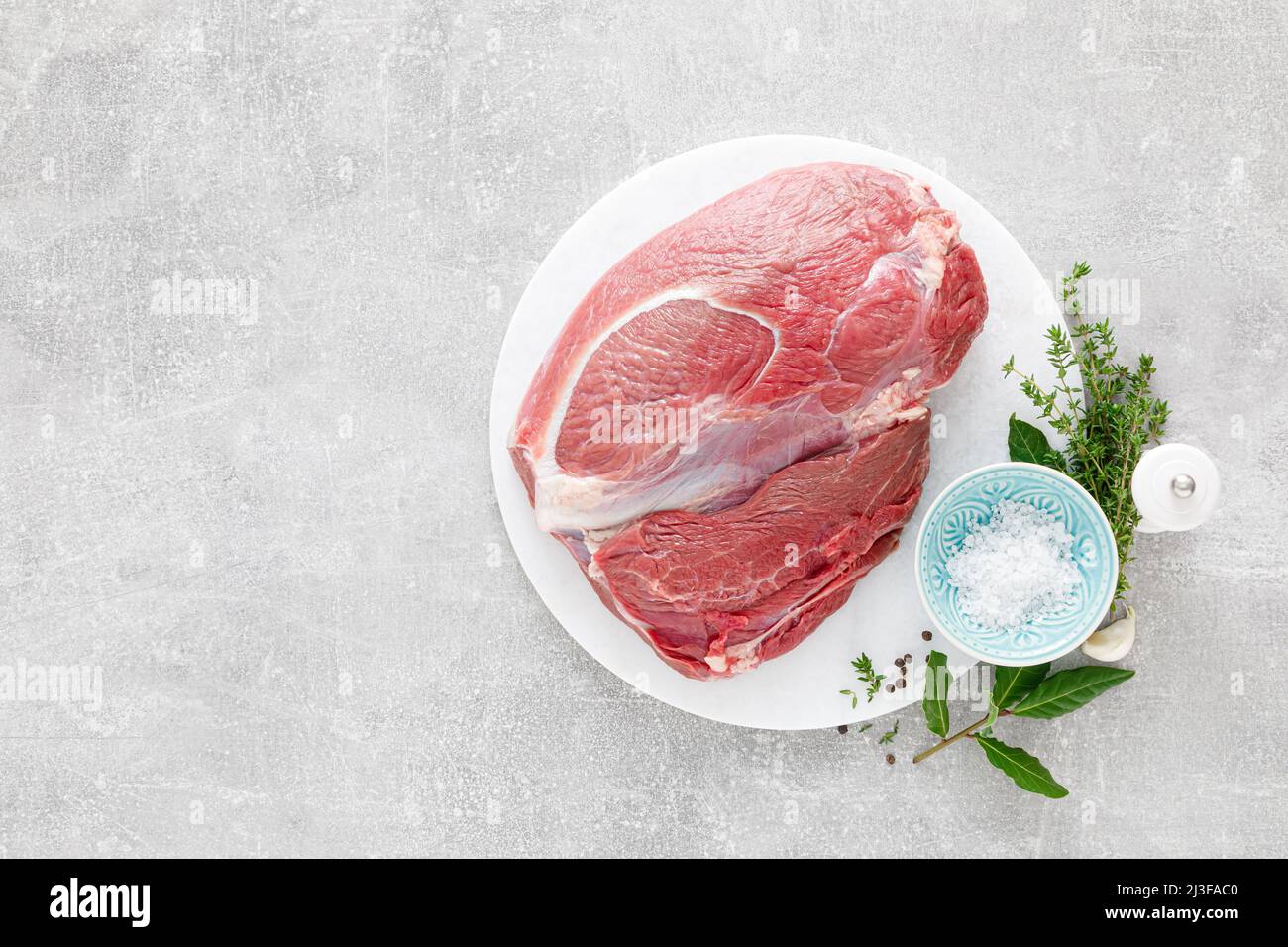 Filet de viande de veau cru sur la planche à découper de cuisine avec ingrédients pour la cuisine, vue de dessus, au-dessus, plat Banque D'Images