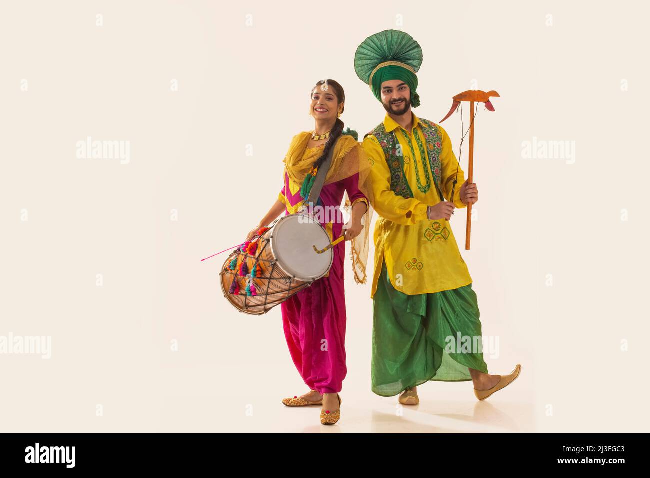 Couple Sikh exécutant bhangra avec tambour et kato pendant la célébration Baisakhi Banque D'Images