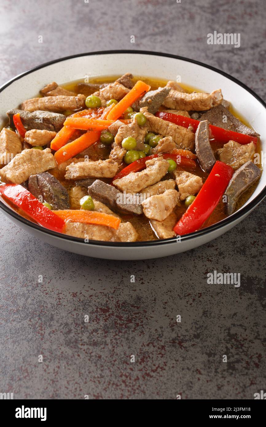 La nourriture philippine Igado est un plat Ilocano populaire fait de filet de porc et d'innards avec des légumes dans l'assiette sur la table. Verticale Banque D'Images