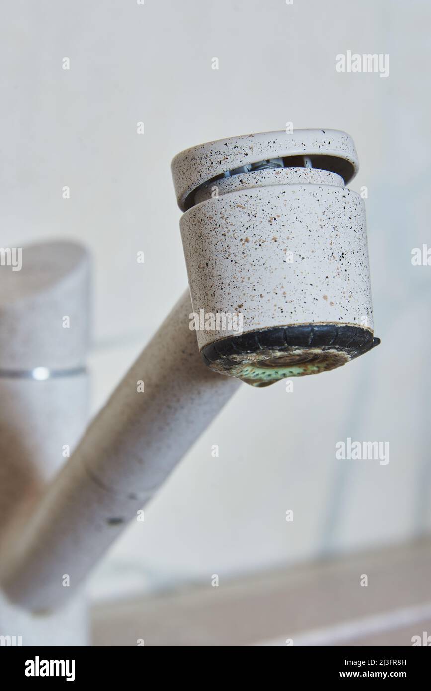 Gros plan d'un robinet beige avec une goutte d'eau sur le fond du mur. Banque D'Images