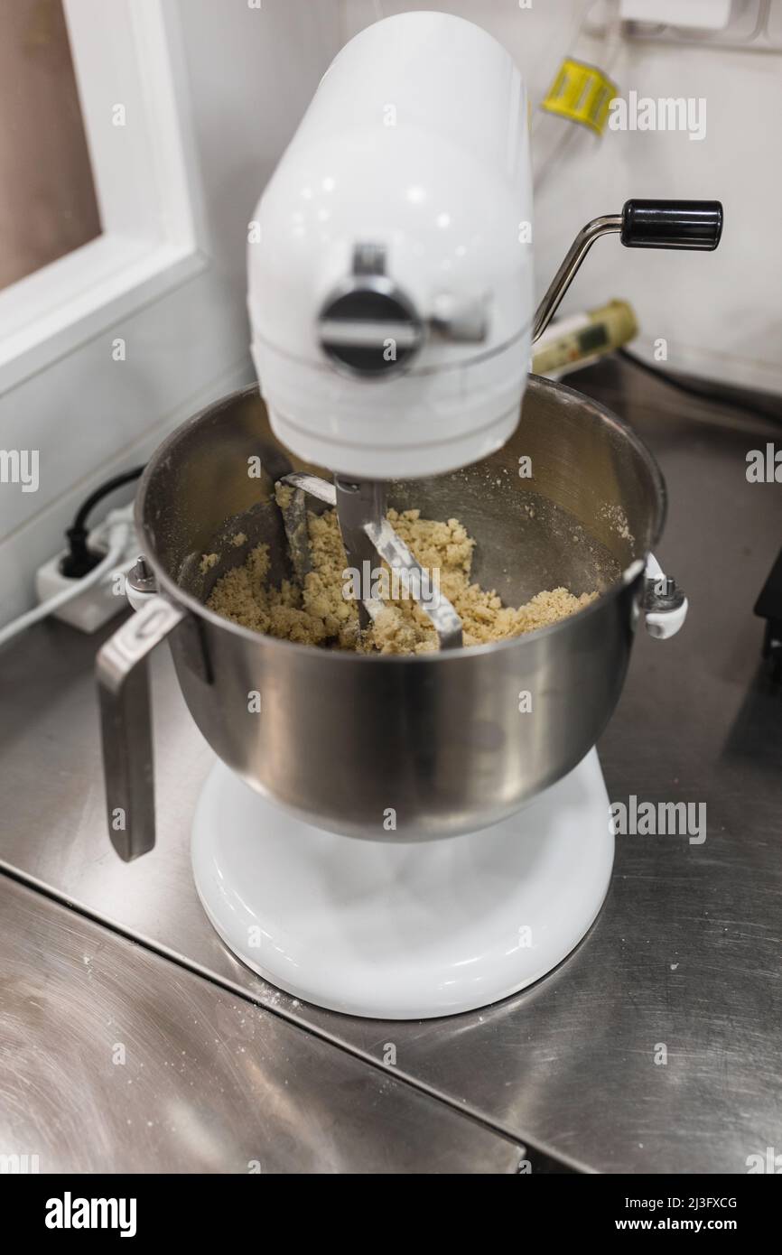 Mélangeur électrique qui bat le mélange dans une pâtisserie Banque D'Images