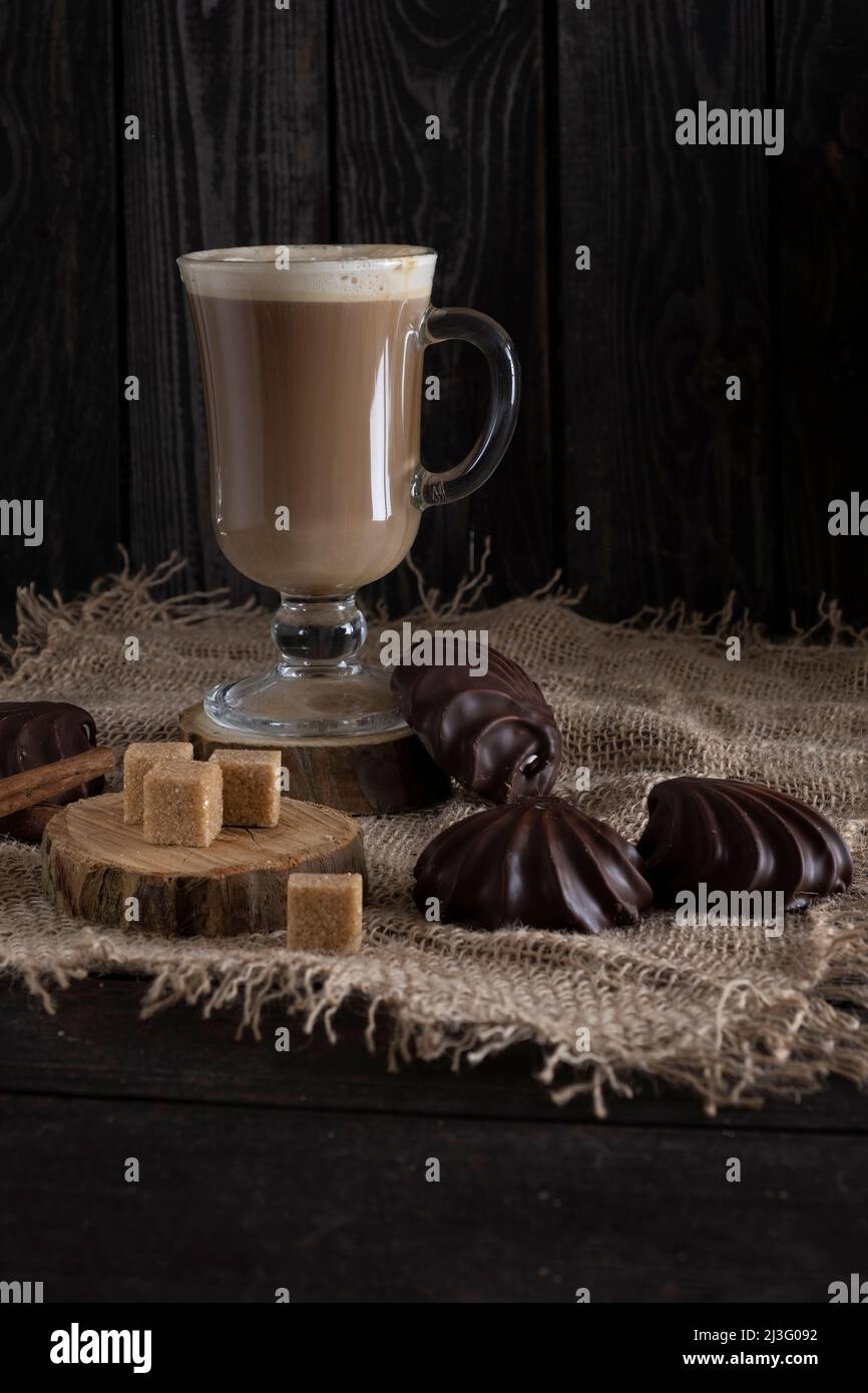 café au lait avec marshmallows au chocolat et sucre de canne sur toile de fond en bois sombre dans un style rustique Banque D'Images