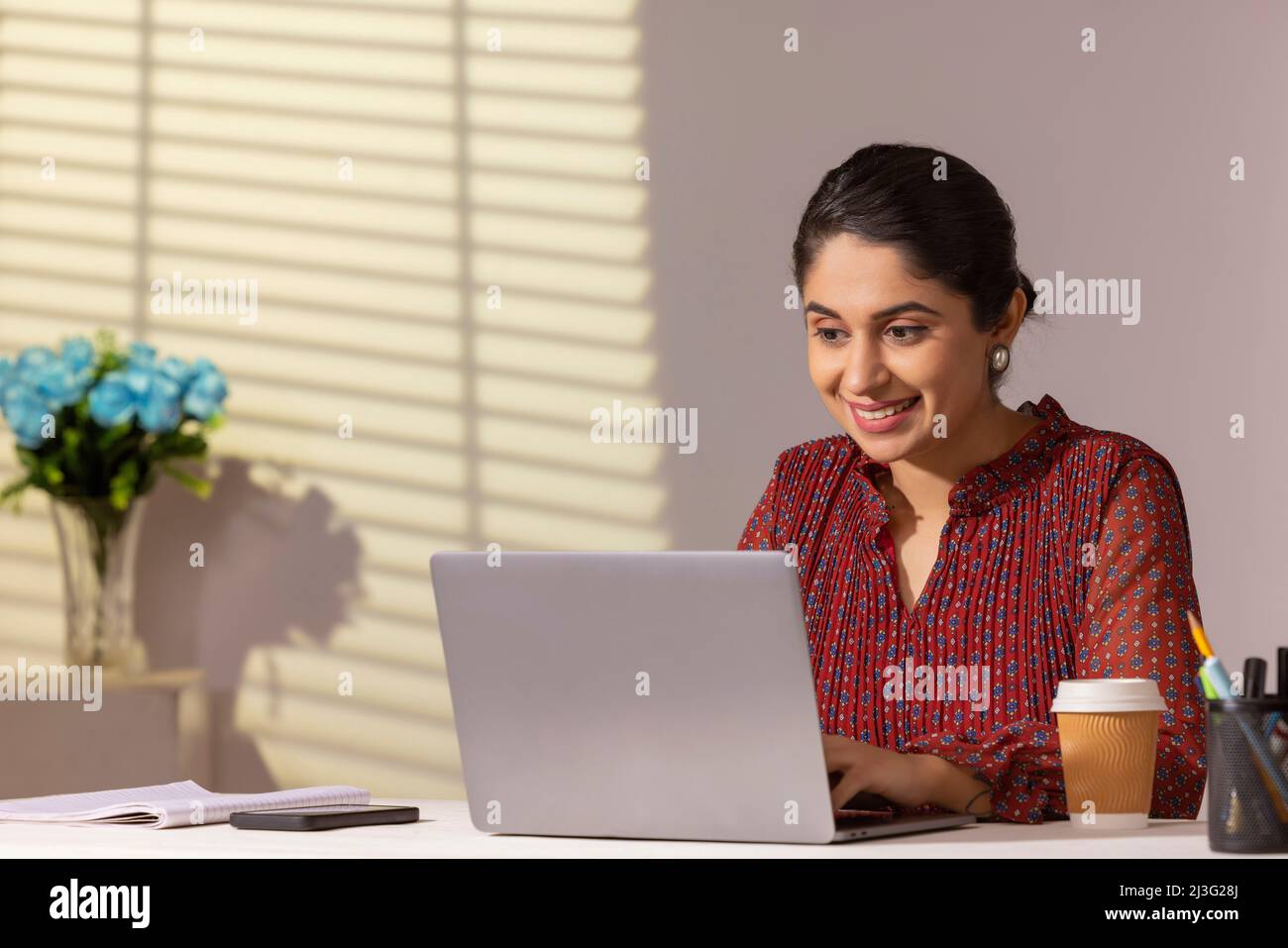 Portrait d'une jeune femme cadre travaillant à son bureau avec un ordinateur portable au bureau Banque D'Images