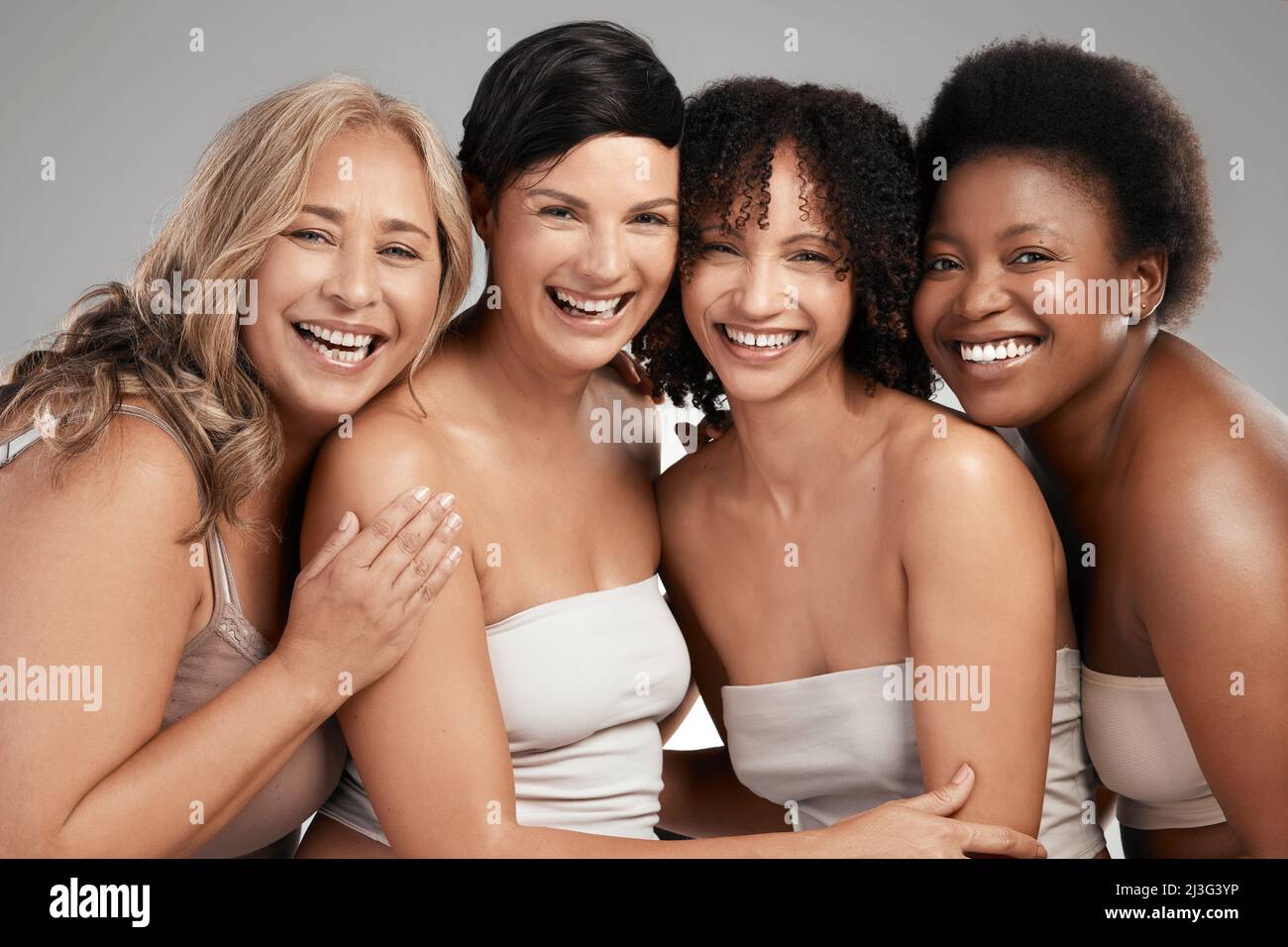 Eh bien ne partagez jamais nos secrets de beauté. Prise de vue d'un groupe diversifié de femmes debout et s'embrassant dans le studio. Banque D'Images