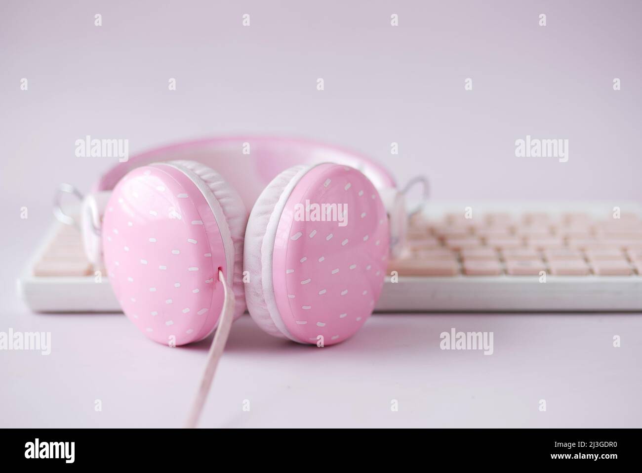 casque de couleur rose sur clavier sur rose . Banque D'Images