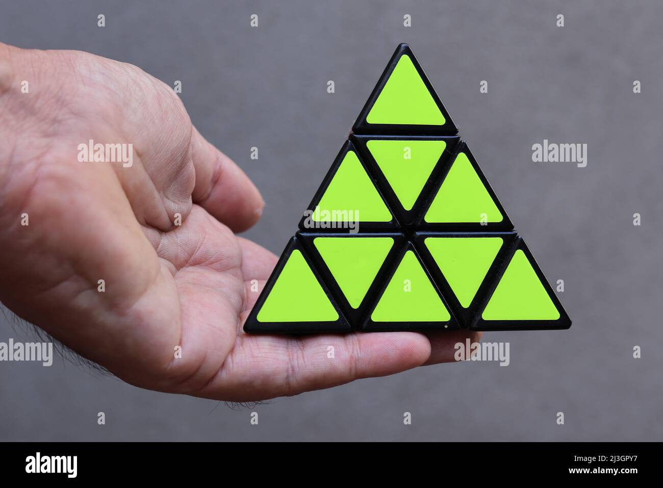 Un puzzle en forme de triangle dans une main Banque D'Images