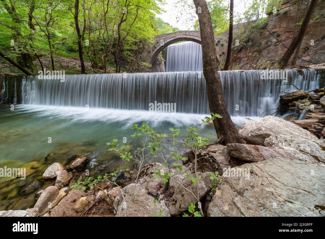 Grèce, Thessalie, double cascade et pont en pierre de Pyli Trikala au coeur de la forêt Banque D'Images