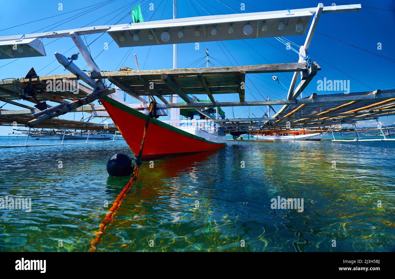 Bateau de pêche traditionnel indonésien le jukung flottant dans le port du village de pêche. Komodo, Indonésie, Asie. Banque D'Images