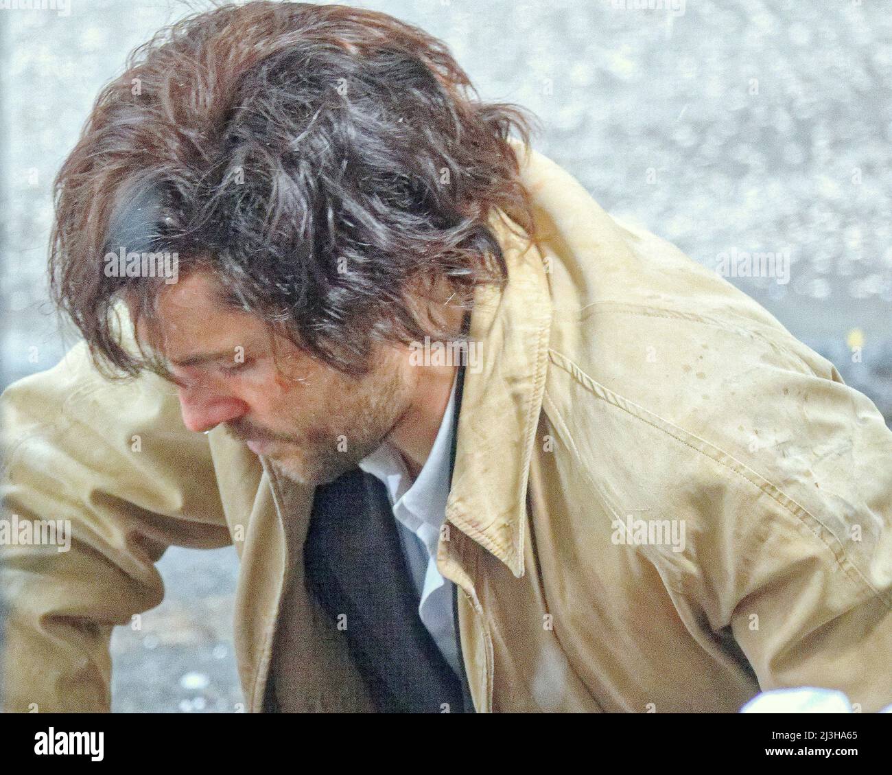Glasgow, Écosse, Royaume-Uni 8th avril 2022. La rue West Nile a été fermée aujourd'hui alors que de la neige et de la grêle tombaient sur le thriller d'Ira Borderlands filmant dans le centre-ville. Colin Morgan se trouve face vers le bas dans le froid et humide pour un gros plan entre les averses de neige et se cache sous un réflecteur pendant eux. Crédit Gerard Ferry/Alay Live News Banque D'Images