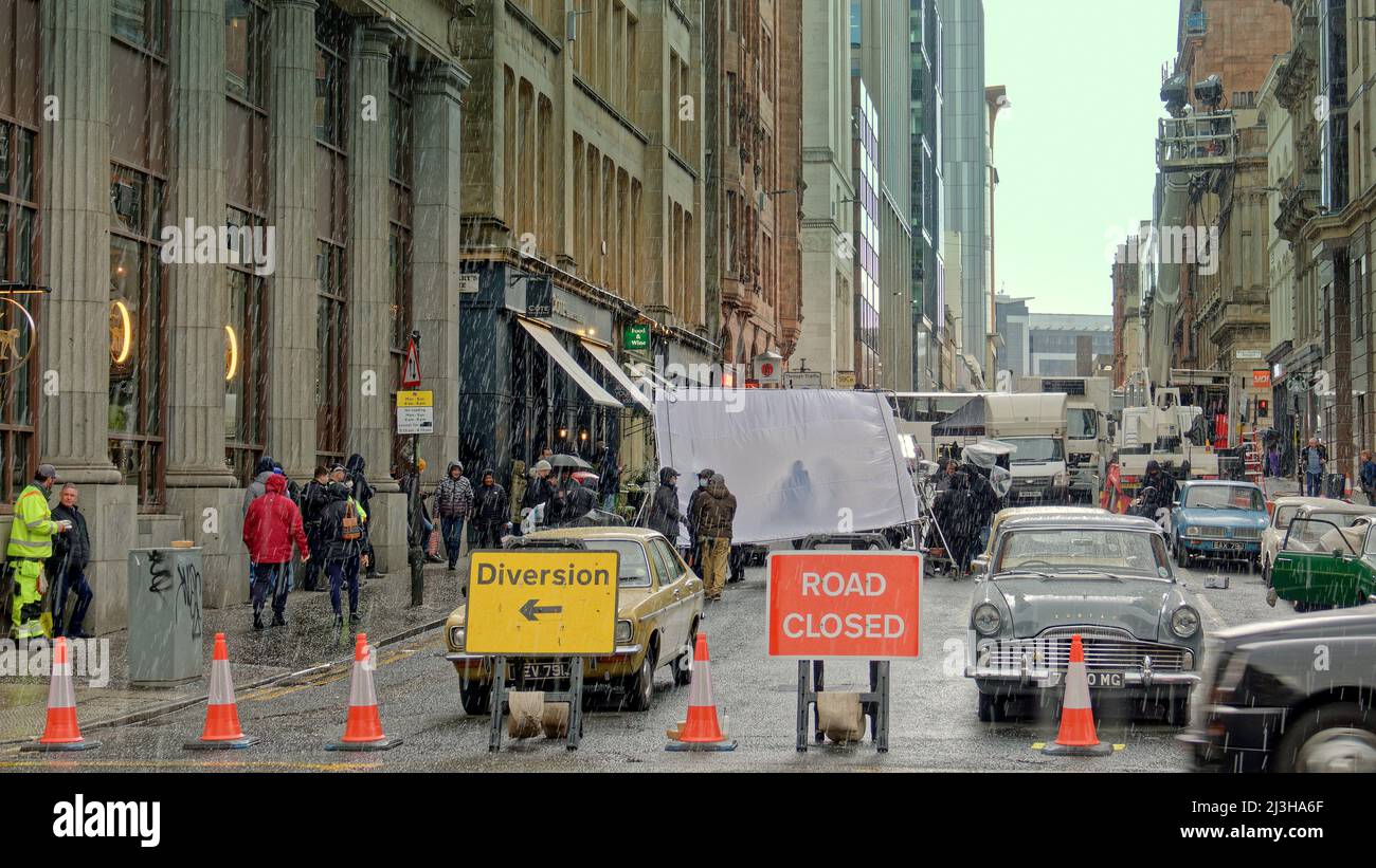 Glasgow, Écosse, Royaume-Uni 8th avril 2022. La rue West Nile a été fermée aujourd'hui alors que de la neige et de la grêle tombaient sur le thriller d'Ira Borderlands filmant dans le centre-ville. Colin Morgan se trouve face vers le bas dans le froid et humide pour un gros plan entre les averses de neige et se cache sous un réflecteur pendant eux. Crédit Gerard Ferry/Alay Live News Banque D'Images