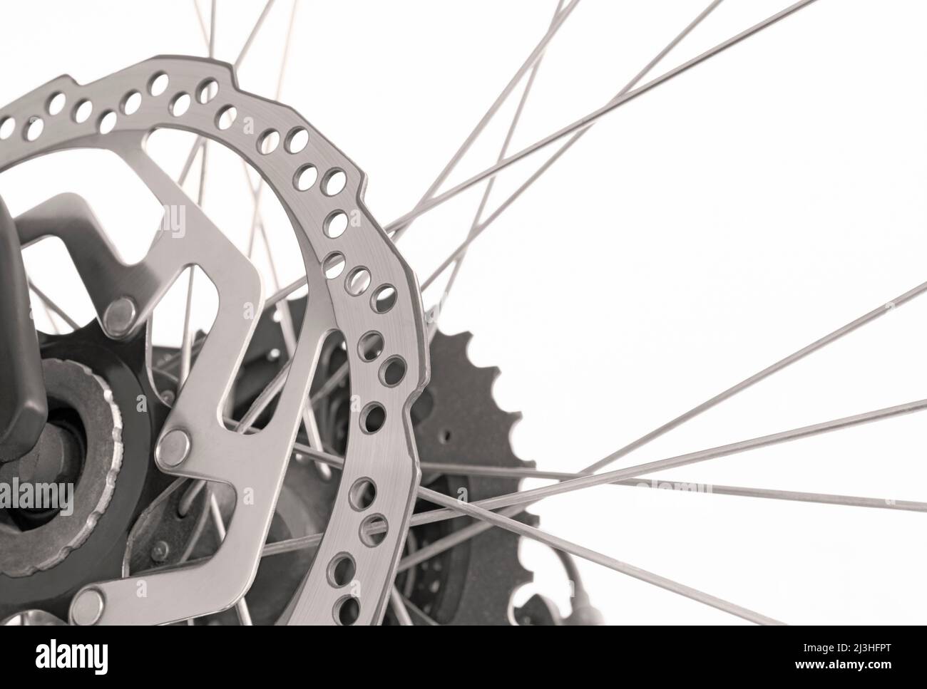 Gros plan du vélo avec disque de frein, pignon et rayons en noir et blanc sur fond blanc Banque D'Images