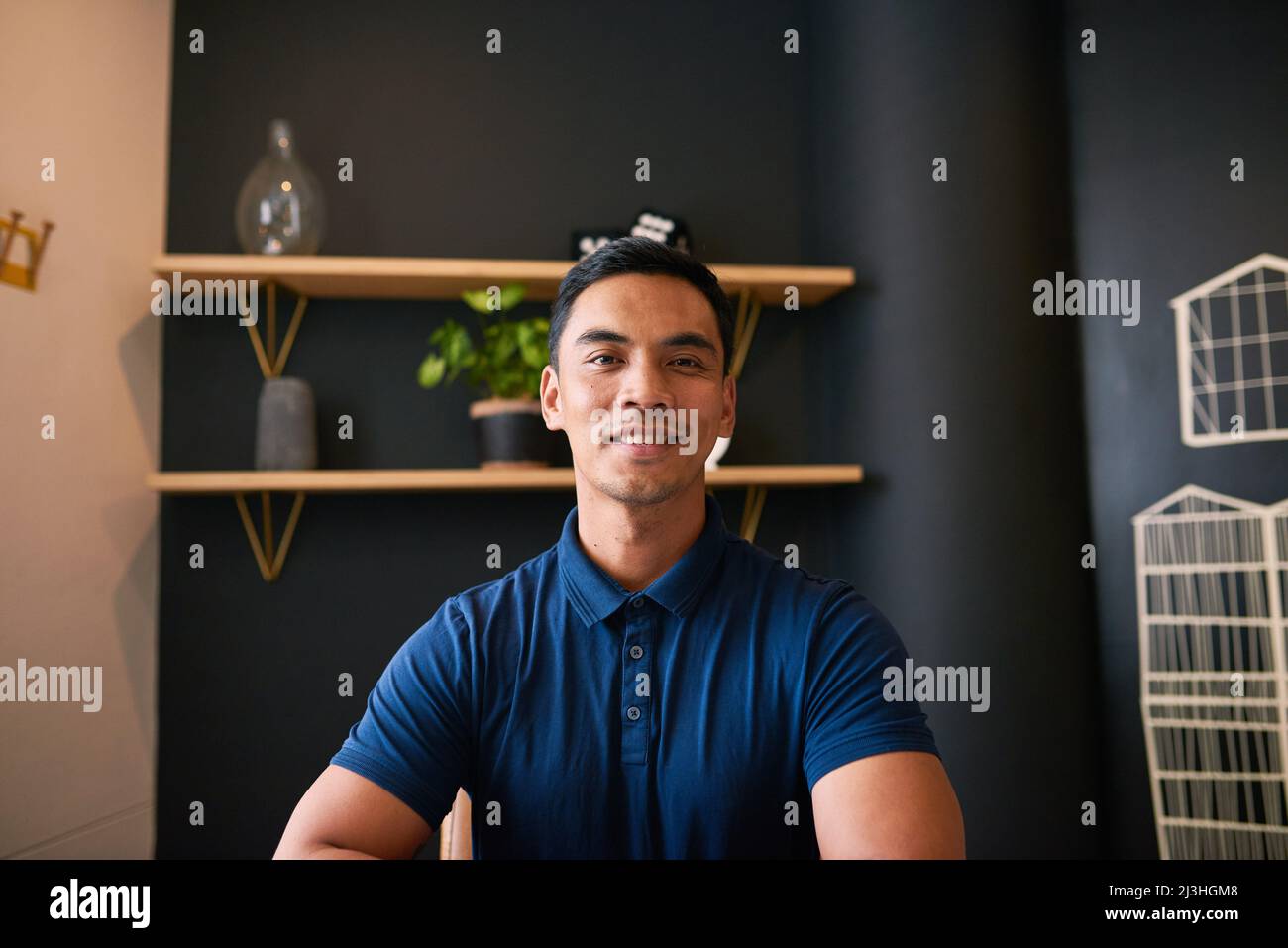Un portrait d'un jeune homme d'affaires asiatique assis au bureau souriant Banque D'Images