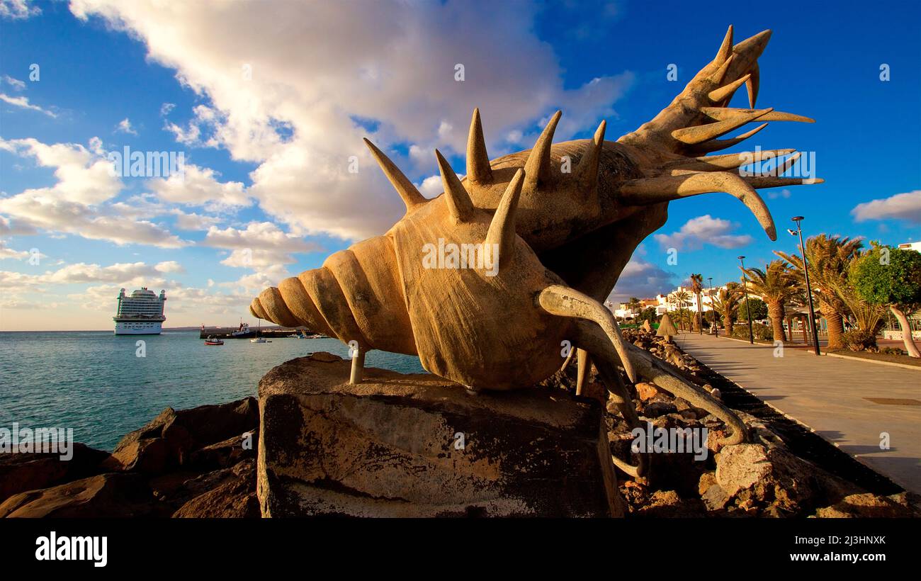 Espagne, îles Canaries, Fuerteventura, capitale, Puerto del Rosario, sculpture d'un escargot de mer, gros plan, mer gauche et poupe d'un bateau de croisière, promenade du port droit, palmiers, bleu ciel, nuages blancs Banque D'Images