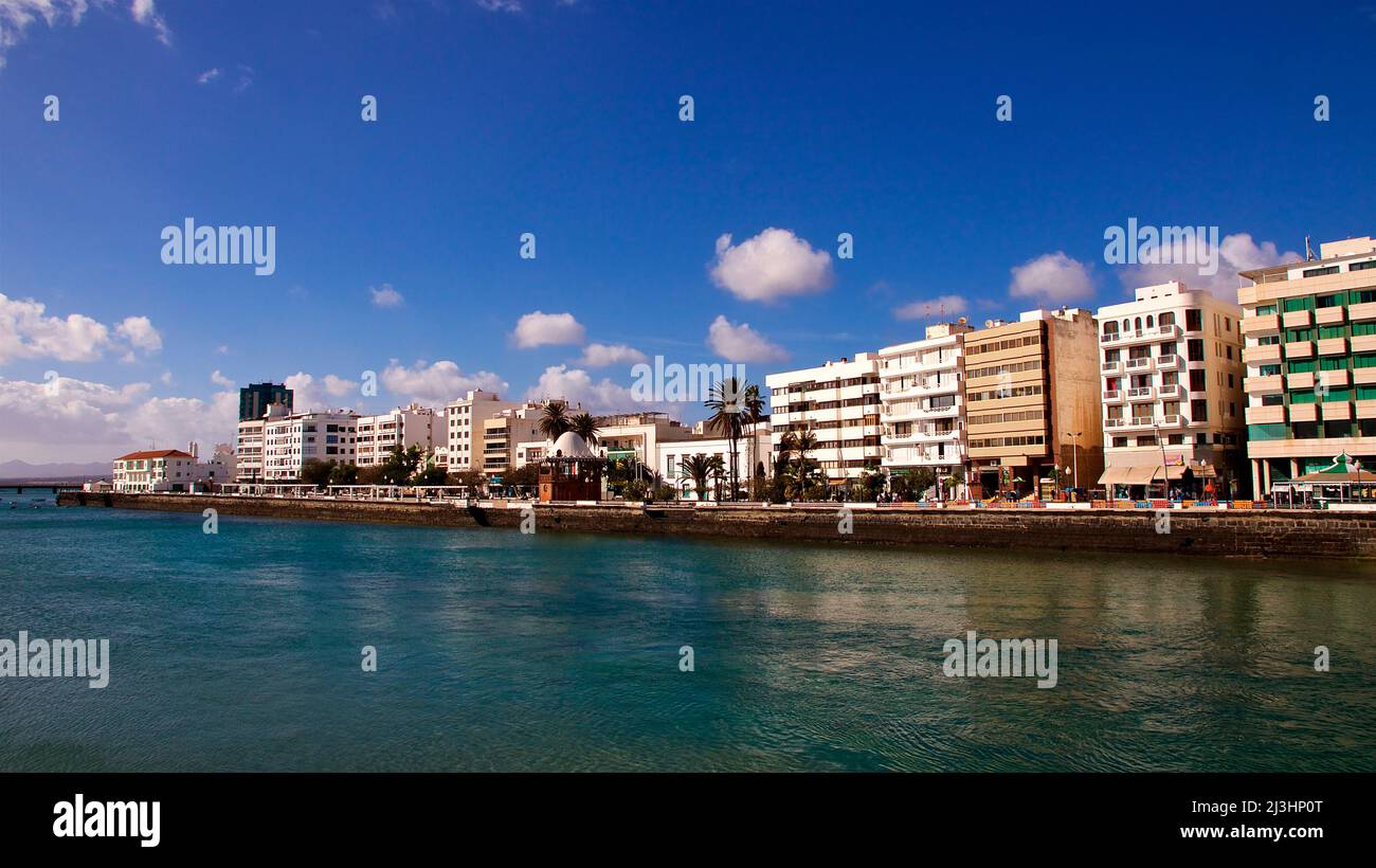 Îles Canaries, Lanzarote, île volcanique, capitale Arrecife, vue de Castillo de San Gabriel à l'horizon d'Arrecife, vert de mer, bleu ciel, nuages blancs, maisons modernes à plusieurs étages Banque D'Images