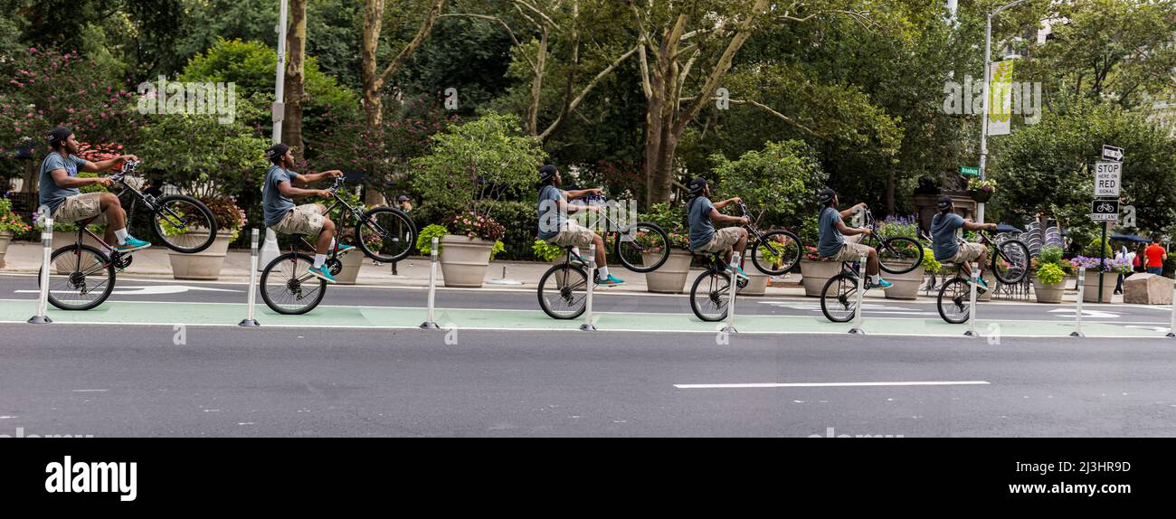 23 Street, New York City, NY, Etats-Unis, Un jeune homme sur son vélo faisant des tours sur une roue Banque D'Images
