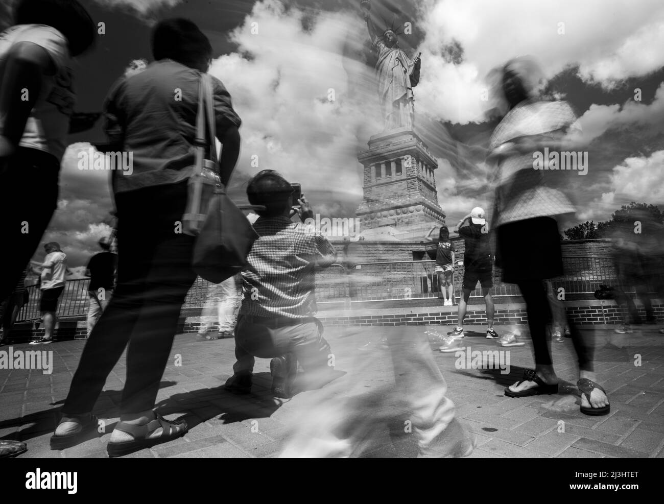 Liberty Island, New York City, NY, Etats-Unis, longue exposition de la Statue de la liberté et des touristes qui sont flous et en mouvement Banque D'Images