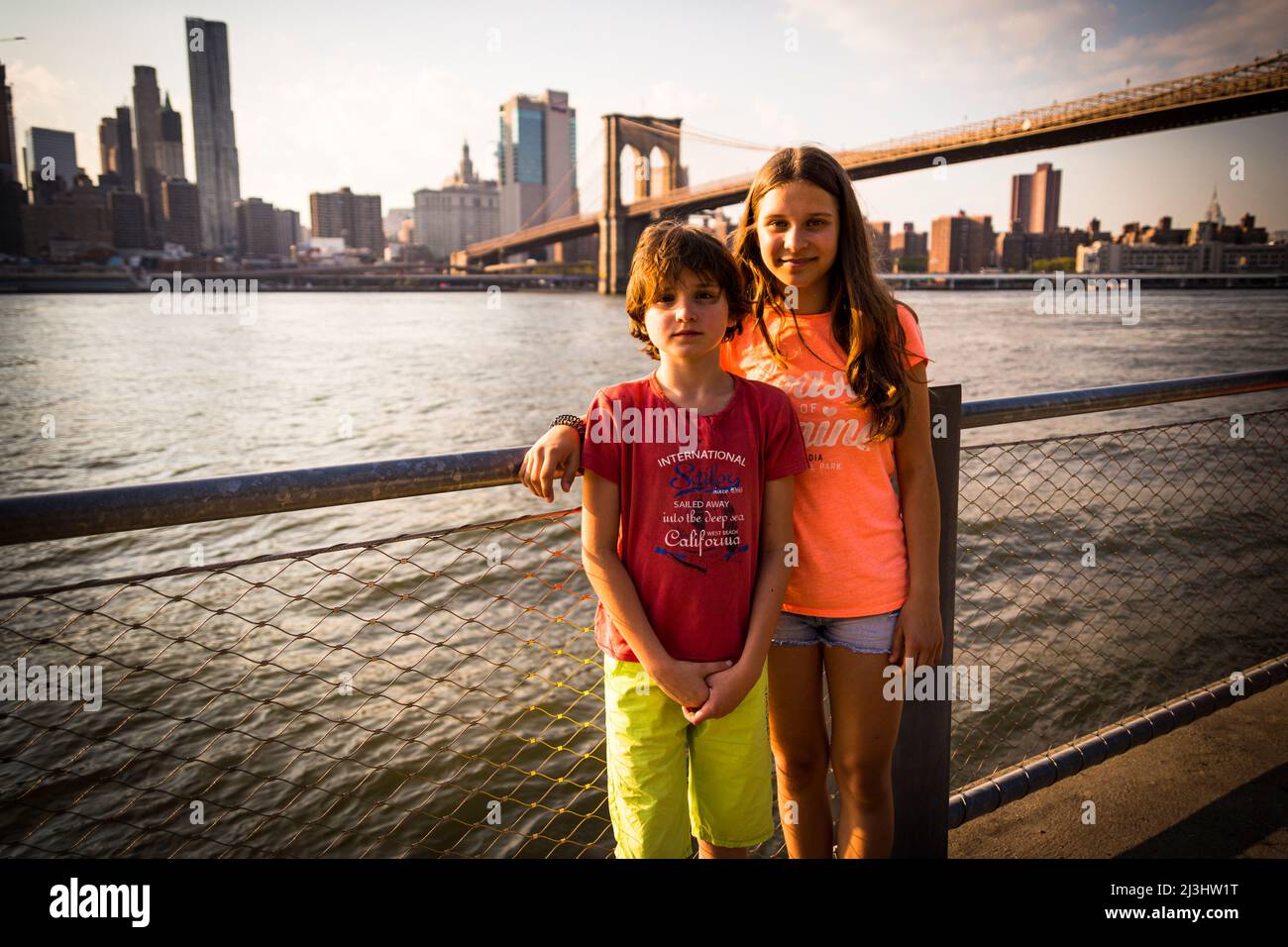 DUMBO/FULTON FERRY, New York City, NY, États-Unis, jeune fille de 14 ans de race blanche et adolescent de 12 ans de race blanche, tous deux avec des cheveux bruns et un style d'été devant le pont de Brooklyn sur East River Banque D'Images