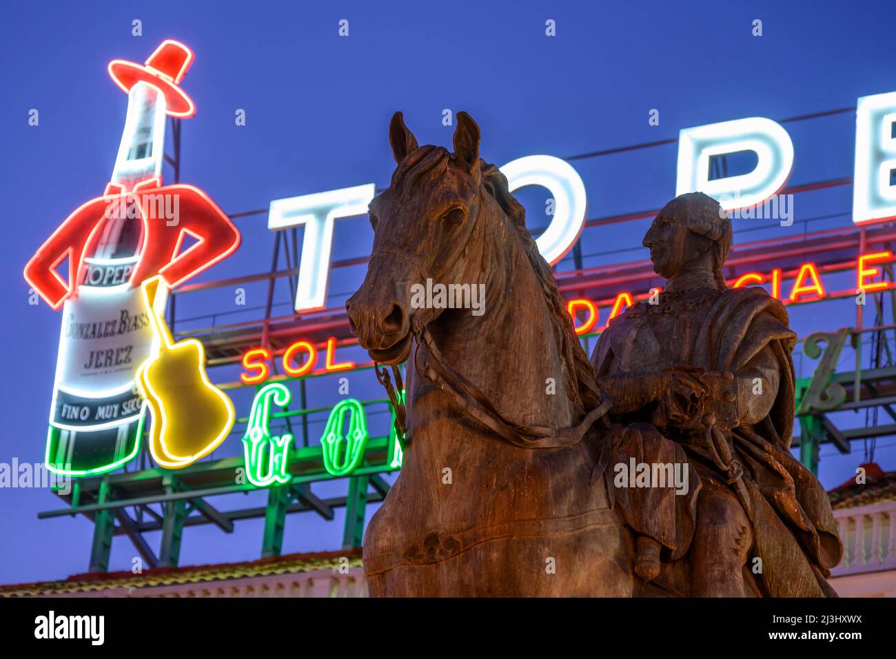 Le célèbre panneau publicitaire de Tio Pepe domine une statue du roi Carlos III, dans la Puerta del sol, dans le centre de Madrid, en Espagne. Banque D'Images