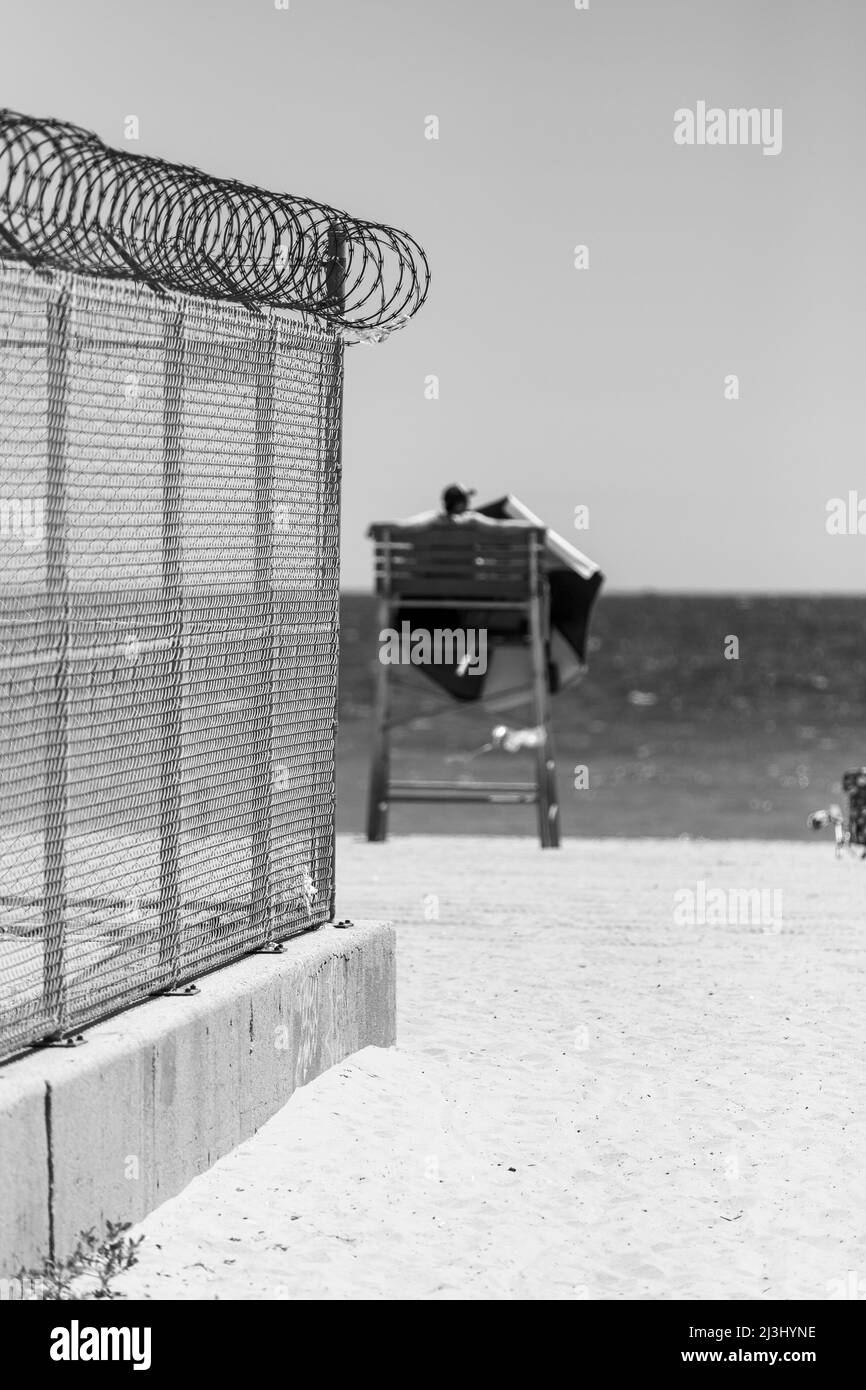 ROCKAWAY BEACH BLVD/NEPONSIT HOSPITAL, New York City, NY, USA, Une clôture, une plage et un sauveteur Banque D'Images