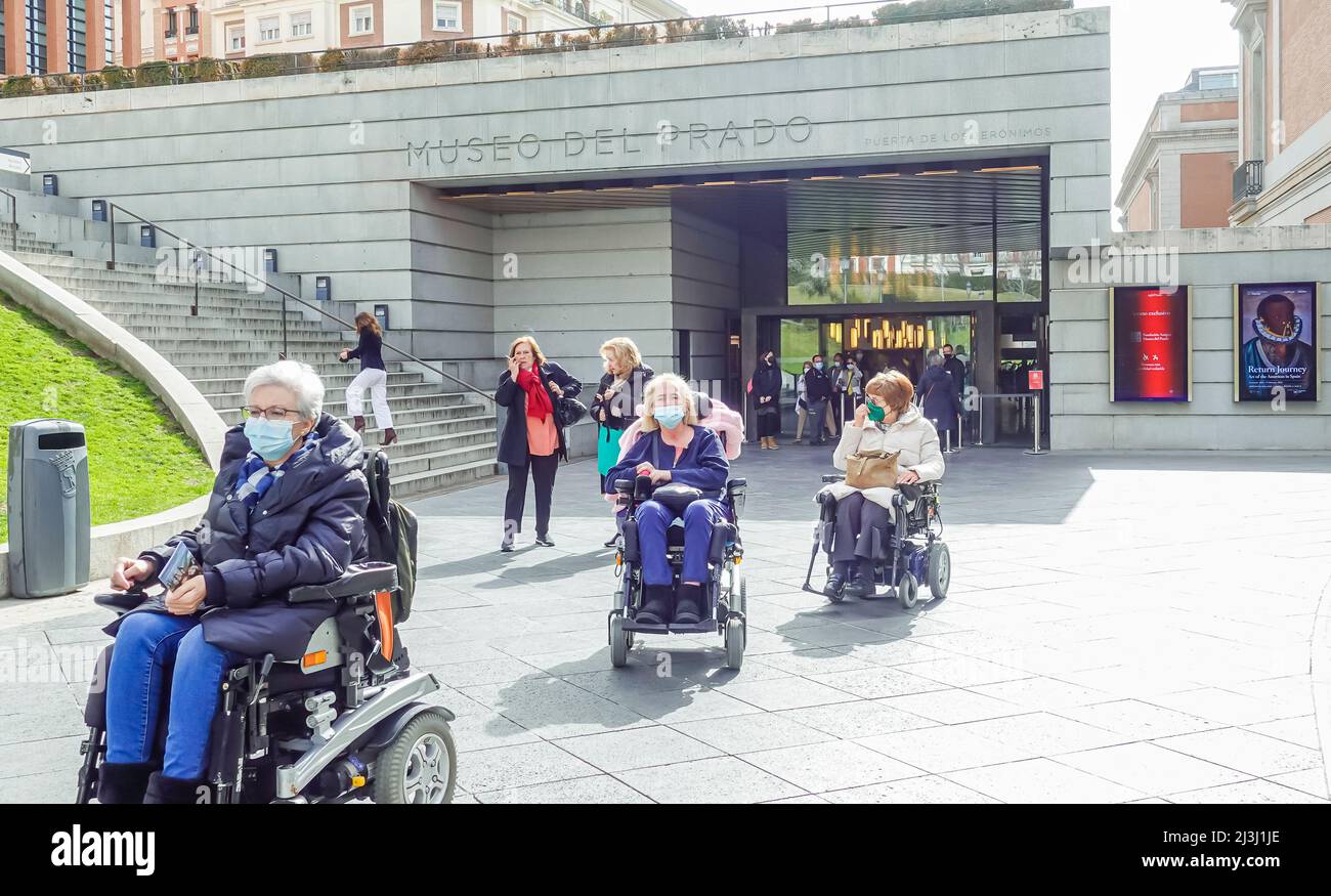Femmes âgées âgées âgées en fauteuil roulant dans des masques faciaux quittant le musée du Prado. Femme dans un appareil de mobilité électrique motorisé en fauteuil roulant. Madrid, Espagne Banque D'Images