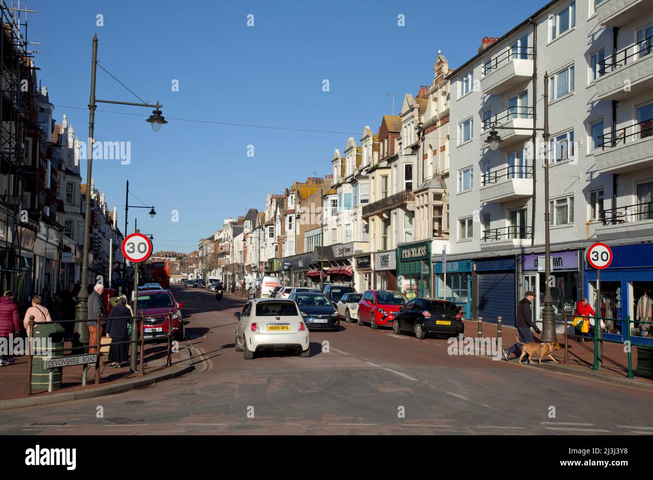 Bexhill-on-Sea, Sussex, Devonshire Road, rue commerçante avec des gens et des voitures Banque D'Images