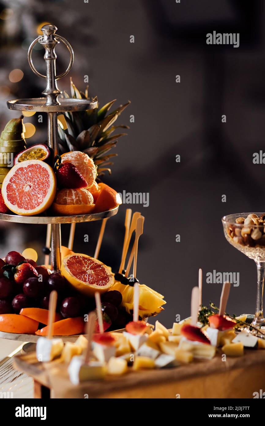 Fruits frais dans l'assiette sur une table en bois. Variété de fruits coupés. Assortiment de fruits. Kiwis,raisin,orange, bananes,pommes,poires. Banque D'Images