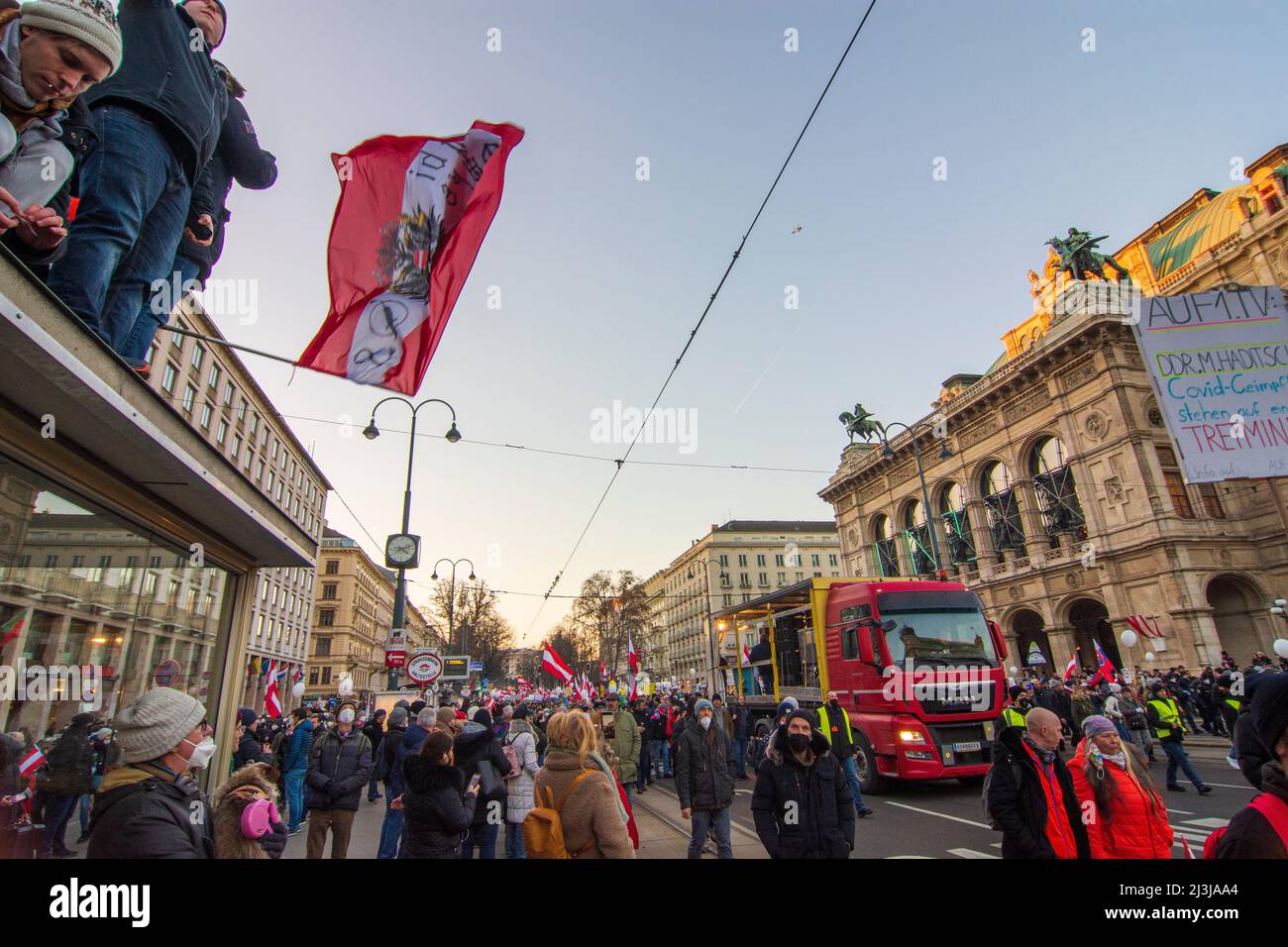 Vienne, manifestation de Corona devant l'opéra Staatsoper, opposants à la marche de corona mesures, homme avec drapeau sur un toit dans le district 01. Vieille ville, Autriche Banque D'Images