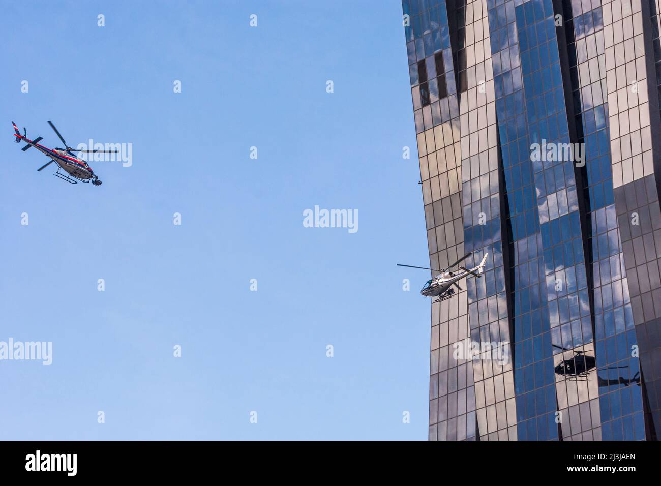 Vienne, 2 hélicoptère pour le tournage du film Netflix 'Tyler Rake ñ extraction' avec l'acteur Chris Hemsworth devant le gratte-ciel DC Tower 1, hélicoptère avec inscription de police est privé et a une caméra montée devant dans le district 22. Donaustadt, Autriche Banque D'Images